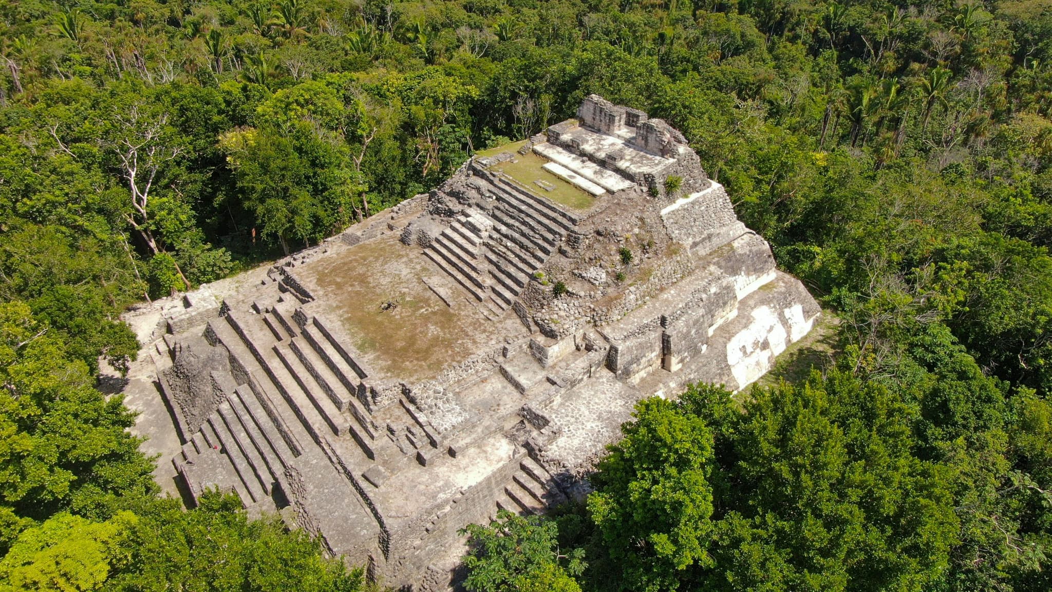 Vista aérea de un sitio arqueológico maya rodeado de selva