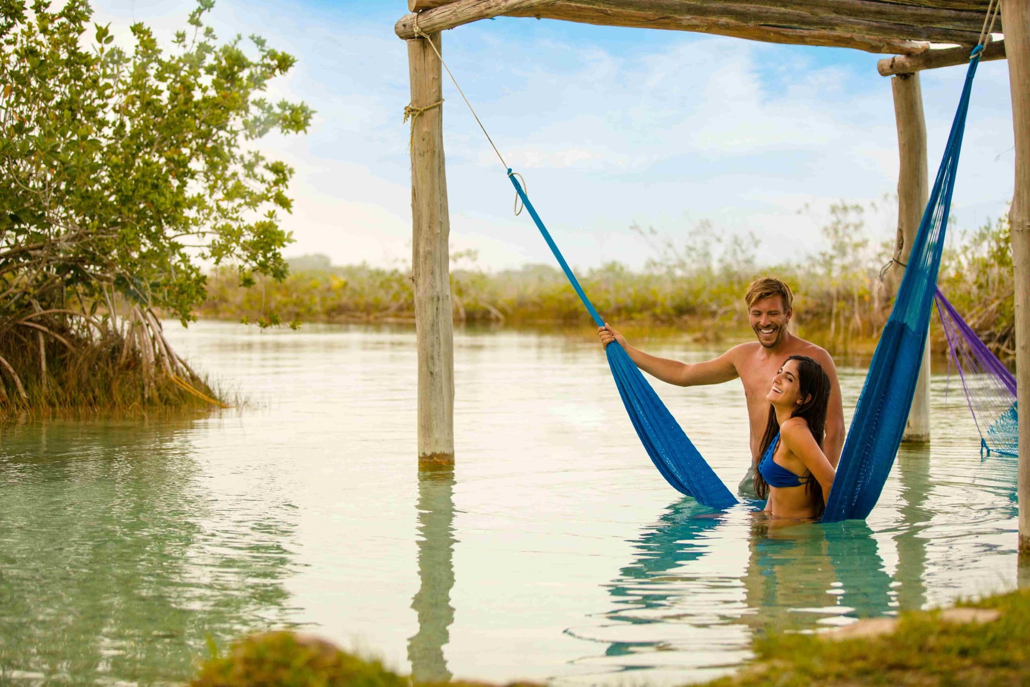 Pareja en una hamaca dentro del agua de la laguna