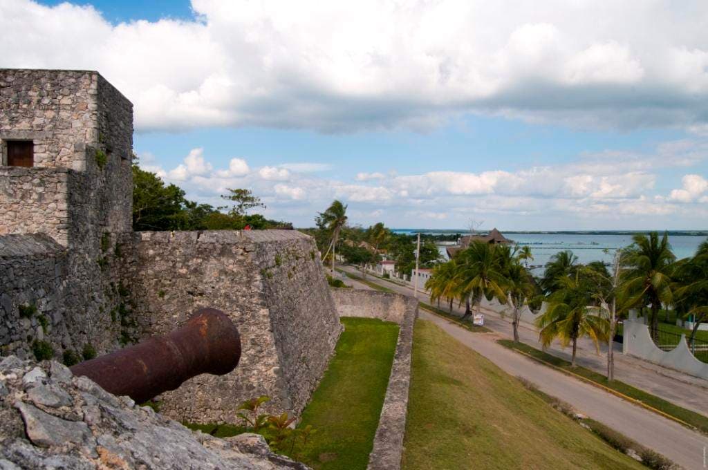 Muralla y cañón del Fuerte de San Felipe con la laguna al fondo